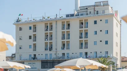 Hotel Blumen vista esterna con ombrelloni in spiaggia e bandiere sul tetto