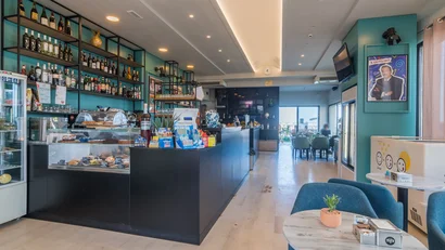 Interno moderno di un bar con bancone e tavoli