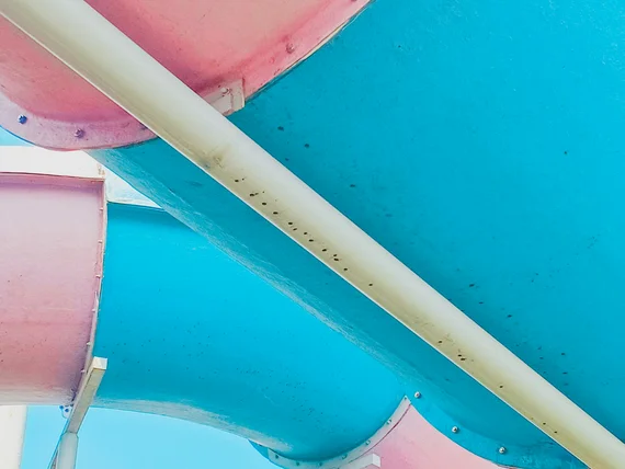 Scivolo acquatico tubolare colorato rosa e azzurro visto dal basso