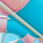 Scivolo acquatico tubolare colorato rosa e azzurro visto dal basso